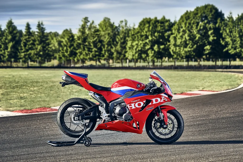 Honda CBR600RR 2027 v červenom na stojane pri okruhu