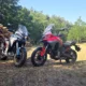 Ducati Multistrada V4 Rally a Multistrada V4 S vedľa seba pri hromade dreva