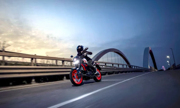 Yamaha MT-125 2027 v zákrute na moste za súmraku